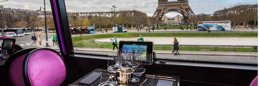 Vista esterna del Bus Toqué davanti alla Torre Eiffel durante un circuito ristorante bus parigi.
